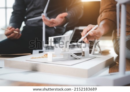 Two engineer design professionals discussion about calculate to use pure energy nature and Installing solar panels on roof house to generate electricity working with model, and Solar panel sample Royalty-Free Stock Photo #2152183689