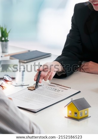Real estate agent holding House model and customer discussing for contract to buy house, insurance or loan real estate concept and background. Royalty-Free Stock Photo #2152186523