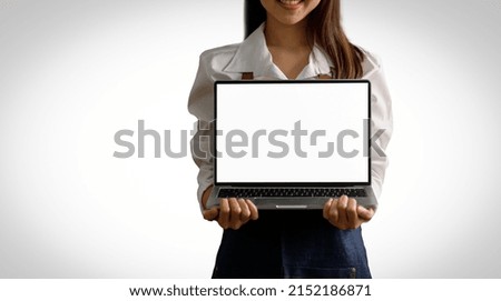 A young Asian business owner shows an Isolated laptop with empty space on white background