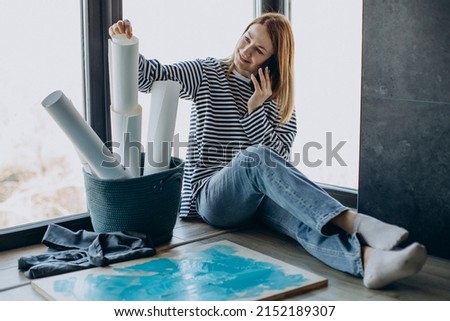 Woman artist painting a picture at home