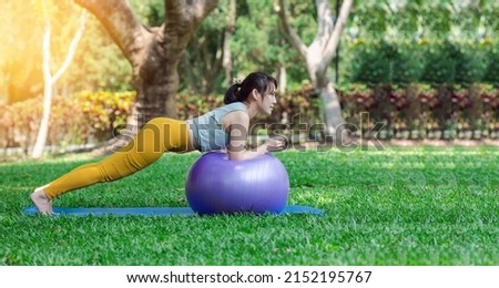 Banner of a young woman practicing yoga with a big ball, meditating in garden. Half Lotus pose with mudra gesture, working out, Well being, wellness concept 