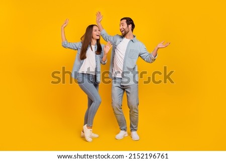 Full length body size view of attractive carefree cheery people dancing having fun isolated over bright yellow color background