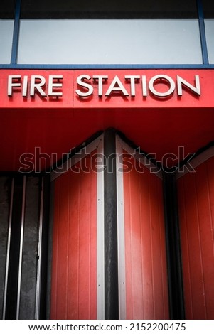 Fire station sign against bright red background Royalty-Free Stock Photo #2152200475