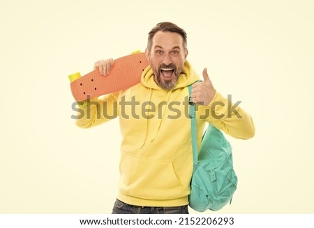 smiling senior guy back to school isolated on white. man in yellow hoody with skateboard.