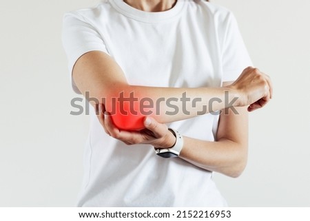 Arm pain and injury for woman. Closeup side body with painful elbow isolated on beige background
