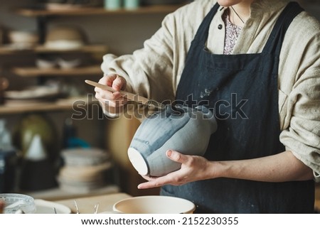 Female artisan business, potter making ceramic vase for sale in handmade store Royalty-Free Stock Photo #2152230355