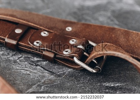 Brown leather unloading for the camera on a dark background