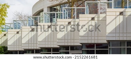 Architecture exterior facade view of modern building wall with lights and shadows. Modern urban architecture is a square shaped building abstract background. Street photo, nobody, selective focus