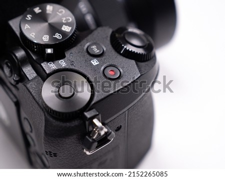 Control buttons and control rings on a mirrorless camera close-up view on a white background