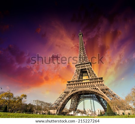 Wonderful view of Eiffel Tower in Paris. La Tour Eiffel with sunset sky and meadows.