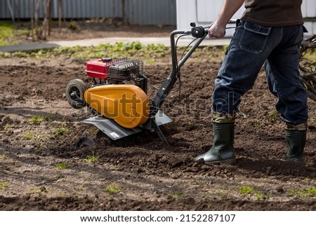 Banner. A male farmer plows the land with a cultivator. Agricultural machinery for tillage in the garden, combine harvester.