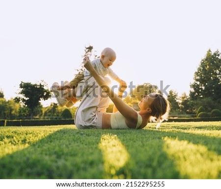 Young mother and baby playing in park at summer. Beautiful mom and child outdoors. Parent with kid spend time together. Happy healthy family at sunlight. Eco sustainable lifestyle. Positive emotions. Royalty-Free Stock Photo #2152295255