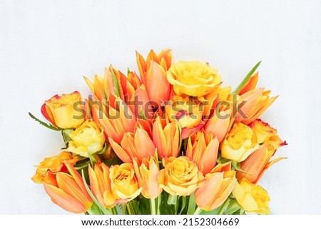 Bunch of bright orange tulips and roses on a white background. Mothers Day, Valentines Day, birthday celebration concept. Top view, copy space Royalty-Free Stock Photo #2152304669