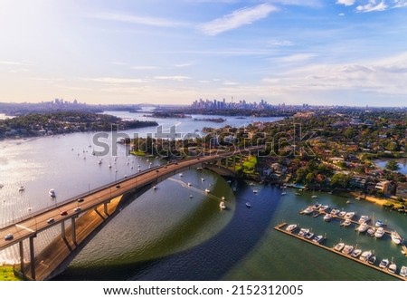 Long arch of Gladesvill bridge across Parramatta river in Sydney West - aerial cityscape to city CBD skyline. Royalty-Free Stock Photo #2152312005