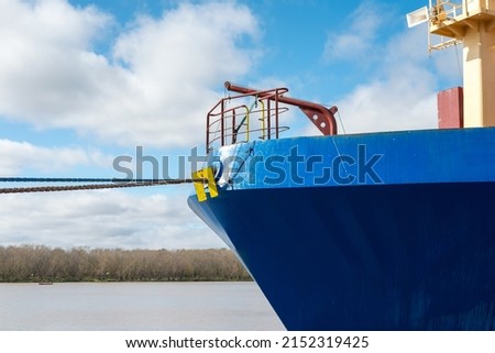 Front view of large blue container cargo ship vessel. Performing cargo export and import operations with horizon line and beautiful sky.