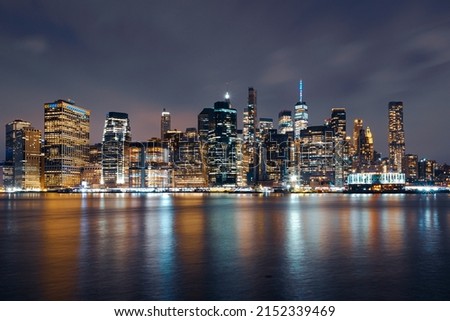 Manhattan Skyline at Night with Buildings Illuminated in Blue and Yellow to Support Ukraine and Colorful East River
