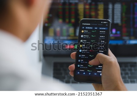 Close up of smartphone of young Asian investor watching the change of cryptocurrency market price. Royalty-Free Stock Photo #2152351367