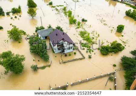 Aerial view of flooded house with dirty water all around it. Royalty-Free Stock Photo #2152354647
