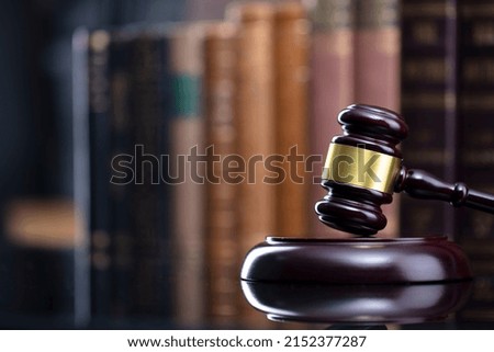 Judge's gavel on bookshelf background. Bokeh.