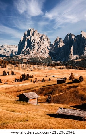 Alpe di Siusi - Seiser Alm- Langkofel mountain group. landscape of Alpine red autumn Alpe di Siusi. hiking nature scenery in dolomites. wooden chalets in Dolomites, Trentino Alto Adige Royalty-Free Stock Photo #2152382341