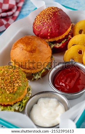 three mini burgers with chicken and meat served with french fries. kids menu