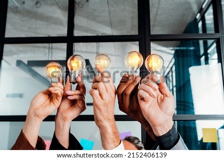 Teamwork and brainstorming concept with businessmen that share an idea with a lamp Royalty-Free Stock Photo #2152406139