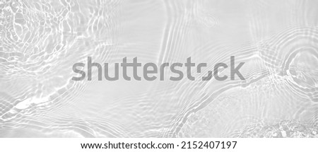 Abstract summer banner background Transparent beige clear water surface texture with ripples and splashes. Water waves in sunlight, copy space, top view. Cosmetics moisturizer micellar toner emulsion Royalty-Free Stock Photo #2152407197