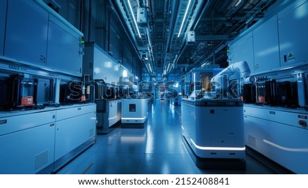 Wide Shot Inside Advanced Semiconductor Production Fab Cleanroom. Automated Robots are Transporting Wafers between Machines. Royalty-Free Stock Photo #2152408841