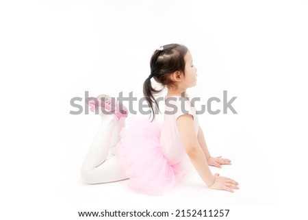 The beautiful little girl is doing gymnastics on a white background