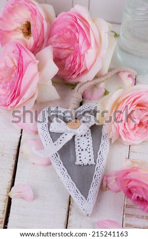 Postcard with fresh roses and decorative heart on  wooden background. Selective focus