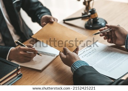 Attorneys are accepting documents from clients who come in to testify in case of embezzlement from business partners who venture into business. The concept of hiring a lawyer for legal proceedings. Royalty-Free Stock Photo #2152425221