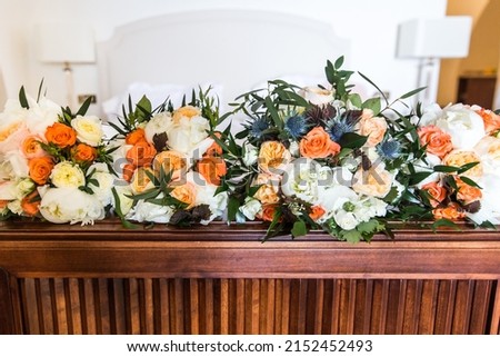 Bouquets of flowers in vase on the wooden table.