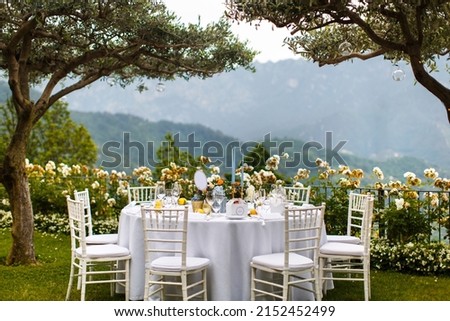 Table set for wedding or another catered event dinner in the garden Royalty-Free Stock Photo #2152452499