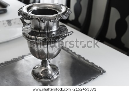 A silver vase stands on a tray, luxury vintage silverware Royalty-Free Stock Photo #2152453391