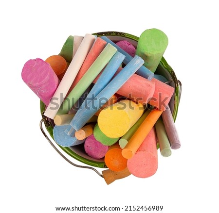 colorful pieces of chalk in a bucket isolated on white background, top view