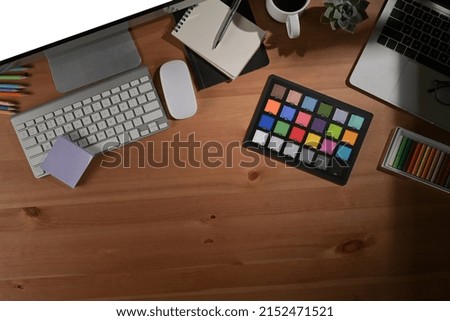 Overhead view graphic designer workplace with computer, coffee cup and color swatch.