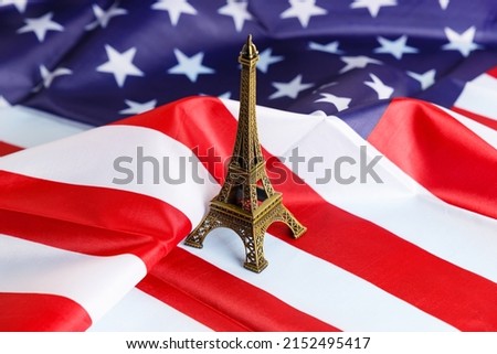 Miniature of the Eiffel Tower on the background of the American flag. Close-up. A place to copy. Travel