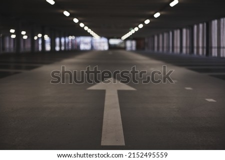 A beautiful shot of a parking space with a bunch of white lights on the ceiling