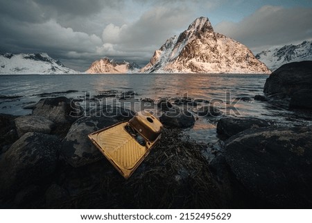 A beautiful view of a rocky ocean with mountains and the sunset in the background
