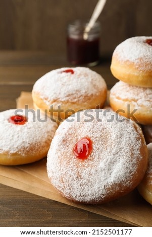 Many delicious donuts with jelly and powdered sugar on wooden table, closeup Royalty-Free Stock Photo #2152501177
