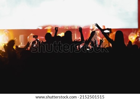 Happy crowd at a concert, people with raised hands at summer music festival