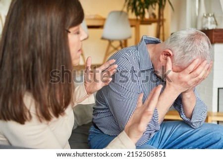 Scolding senior woman and a crying man arguing as a relationship conflict concept