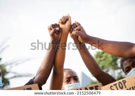 Close-up of the raised fists of a group of African guys protesting Royalty-Free Stock Photo #2152506479