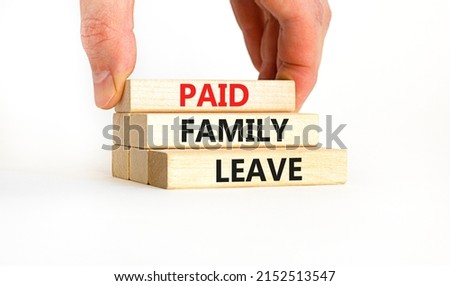 Paid family leave symbol. Concept words Paid family leave on wooden blocks. Doctor hand. Beautiful white table white background. Business medical and paid family leave concept. Copy space.