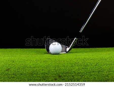 Golf ready to play on green grass with black background.
