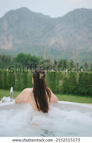 woman in open-air bath with mountain view She is relaxing in the outdoor bath and enjoying the holidays. with tourism Thai travel lifestyle photography