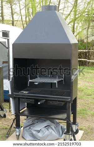 Modern black metal barbecue in the countryside