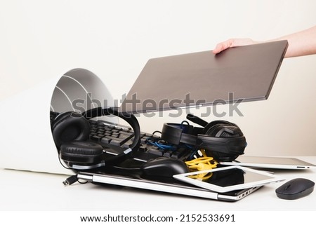 Woman hand put used laptop to recycling bin full of old computers, phones, tablets, cords and electronic devices. Planned obsolescence, e-waste, electronics waste for reuse and recycle concept Royalty-Free Stock Photo #2152533691
