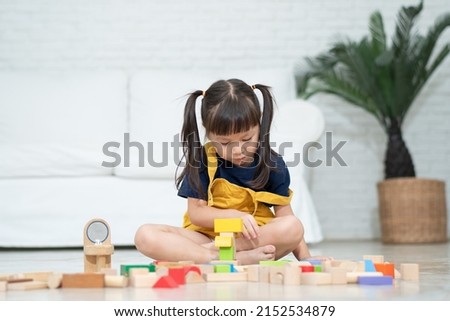 Cute asian little girl playing with colorful toy blocks, Kids play with educational toys at kindergarten or daycare. Creative playing of kid development concept, Toddler kid in nursery.