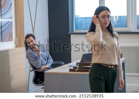 Pleased young boss staring after his secretary Royalty-Free Stock Photo #2152538935